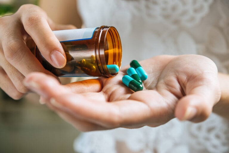 Woman S Hand Pours Medicine Pills Out Bottle Scaled.jpg